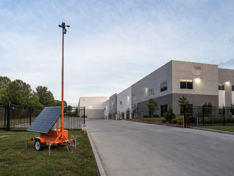 Mobile security camera trailer monitoring a vacant multifamily property entrance